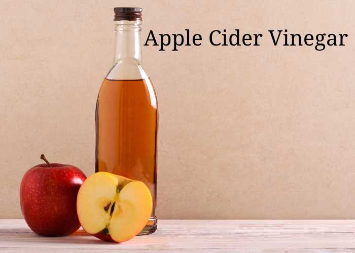 Bottle of apple cider vinegar with fresh apples